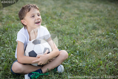 Image of Portrait of a young  boy with soccer ball.