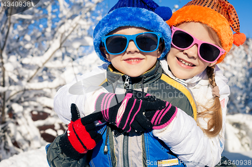 Image of Happy little children playing  in winter snow day.