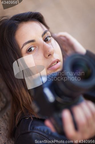 Image of Young Adult Ethnic Female Photographer Against Wall Holding Came