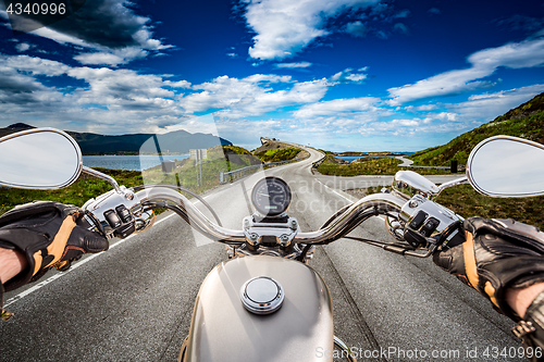 Image of Biker rides a road with Atlantic Ocean Road in Norway. First-per