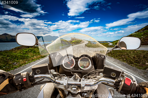 Image of Biker rides a road with Atlantic Ocean Road in Norway. First-per