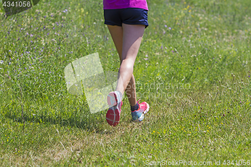 Image of Young Woman running marathon outdoors