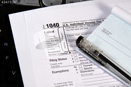 Image of Preparing Taxes - Check and Forms on Keyboard
