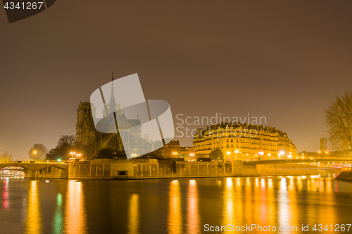 Image of Notre Dame Cathedral with Paris cityscape at dusk