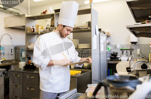 Image of chef with clipboard doing inventory at kitchen