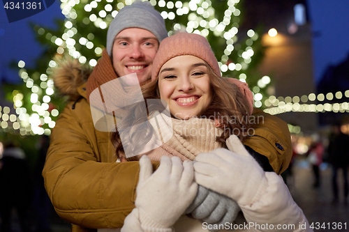 Image of happy couple hugging at christmas tree