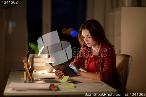 Image of student girl or woman with tablet pc at night home