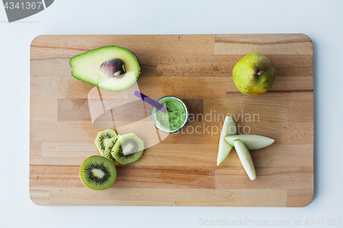 Image of jar with fruit puree or baby food on wooden board