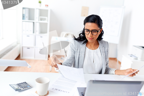 Image of businesswoman with laptop working at office