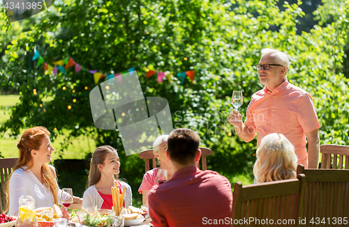 Image of happy family having dinner or summer garden party