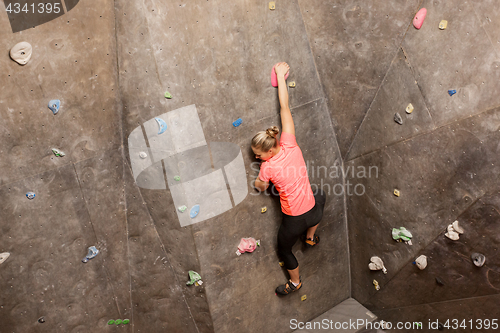 Image of young woman exercising at indoor climbing gym