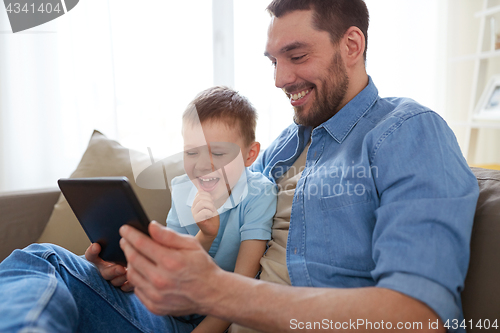 Image of father and son with tablet pc playing at home