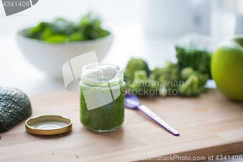 Image of jar with puree or baby food on wooden board