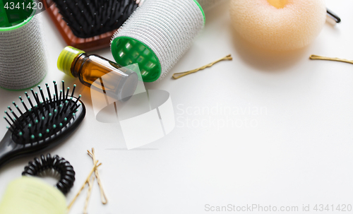 Image of hair brushes, oil, curlers and pins