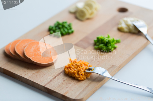 Image of mashed fruits and vegetables with forks on board