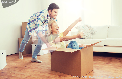 Image of happy couple having fun with boxes at new home