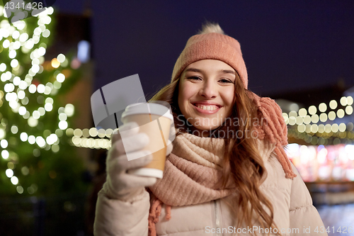 Image of happy young woman with coffee at christmas market