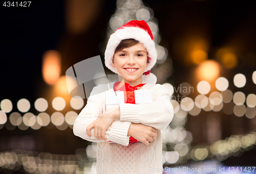 Image of smiling happy boy in santa hat with christmas gift