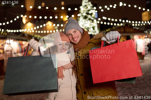 Image of happy couple at with shopping bags in winter