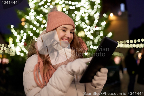 Image of woman with tablet pc at christmas tree outdoors