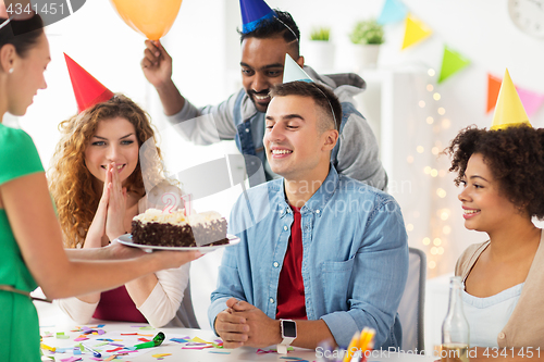 Image of team greeting colleague at office birthday party