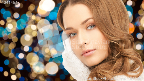 Image of young woman in gloves over christmas lights