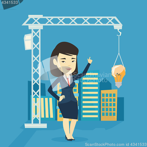 Image of Woman pointing at idea bulb hanging on crane.