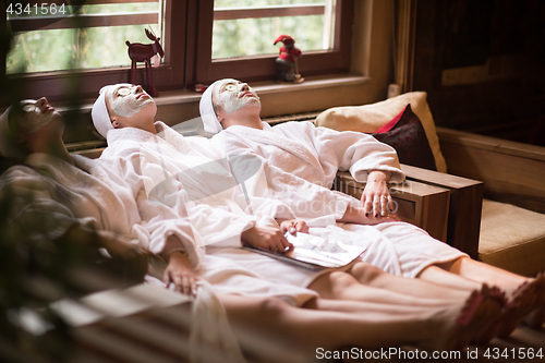 Image of women is getting facial clay mask at spa