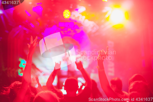 Image of The silhouettes of concert crowd in front of bright stage lights