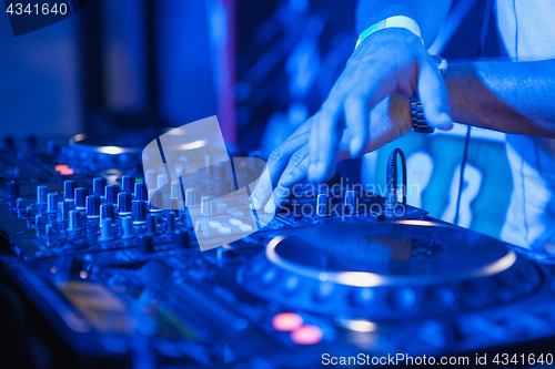Image of DJ playing music at mixer on colorful blurred background