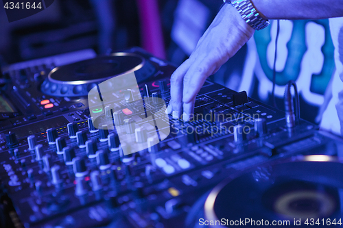 Image of DJ playing music at mixer on colorful blurred background