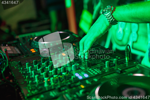 Image of DJ playing music at mixer on colorful blurred background