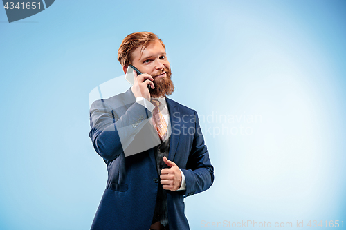 Image of The barded man in a suit holding cane.