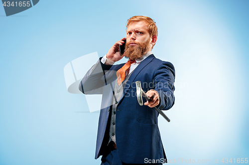 Image of The barded man in a suit holding cane.