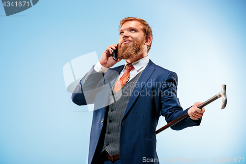 Image of The barded man in a suit holding cane.