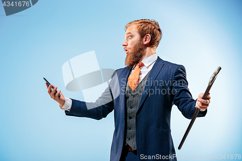 Image of The barded man in a suit holding cane.