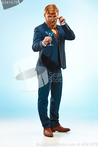 Image of The barded man in a suit holding cane.