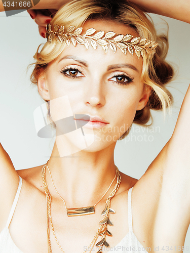 Image of young blond woman dressed like ancient greek godess, gold jewelr