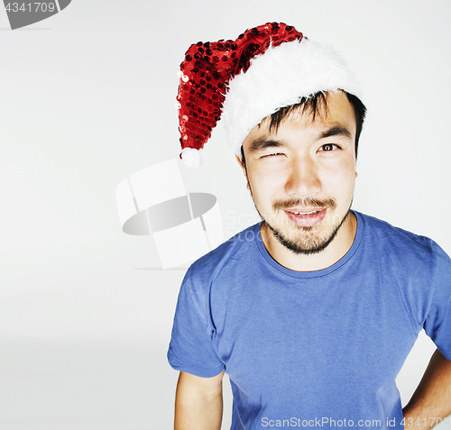 Image of funy exotical asian Santa claus in new years red hat smiling