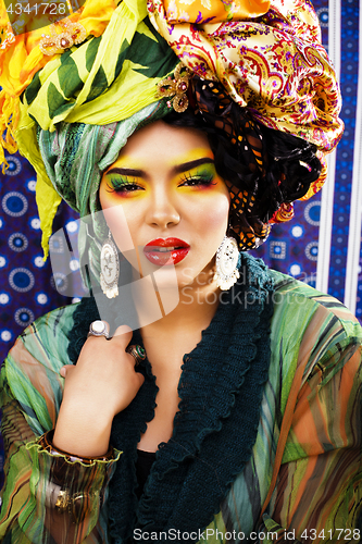 Image of beauty bright woman with creative make up, many shawls on head l