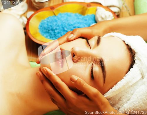 Image of stock photo attractive lady getting spa treatment in salon, close up asian hands on face