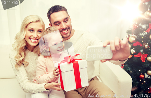 Image of family taking selfie with smartphone at christmas