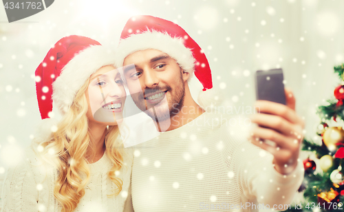 Image of couple taking selfie with smartphone at christmas