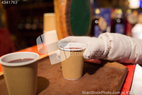 Image of hand with cup of mulled wine at christmas market