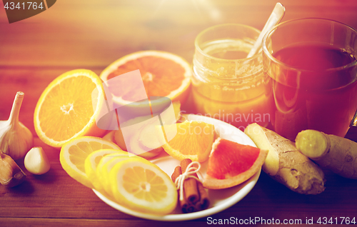 Image of ginger tea with honey, citrus and garlic on wood