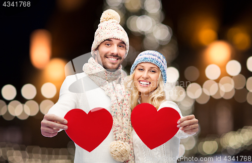 Image of couple with red hearts over christmas lights