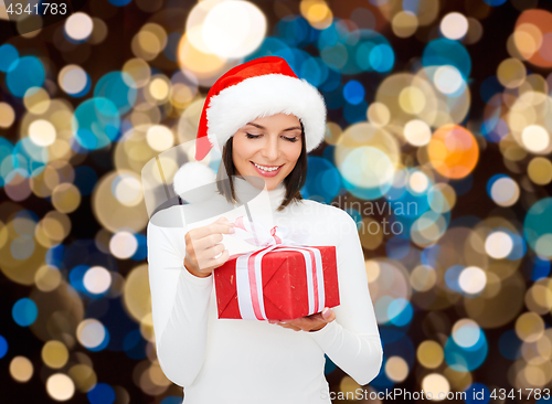 Image of smiling woman in santa hat with christmas gift