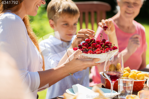 Image of happy family having dinner or summer garden party