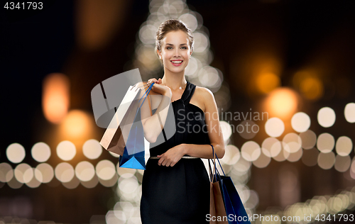 Image of woman in black with shopping bags at christmas