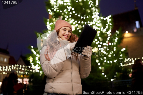 Image of woman with tablet pc at christmas tree outdoors